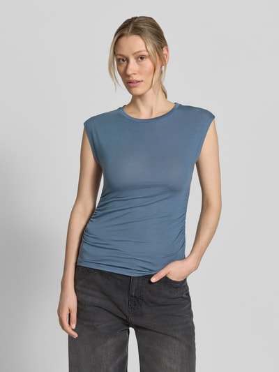 Frauenmodel trägt Slim Fit T-Shirt aus Lyocell-Mix Modell 'AVASARAH' von Vero Moda, Optik: Unifarben, Passform: Slim-Fit, Seitliche Raffungen, Rundhals, Ärmelform: Kurzarm, Damen T-Shirt, Ganzkörperansicht von vorne.