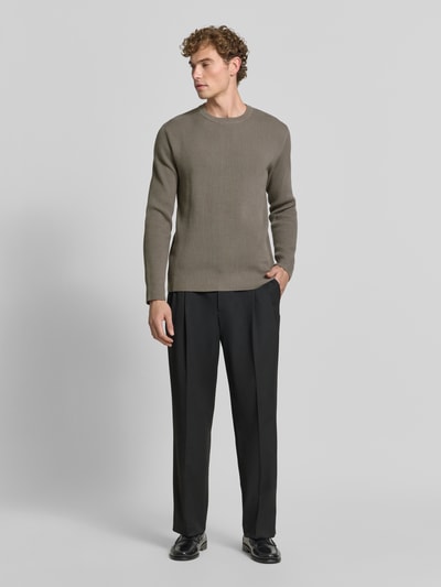 Männermodel trägt Slim Fit Strickpullover Baumwoll-Mix von Lindbergh in gerippter Optik, Ganzkörperansicht von vorne.
