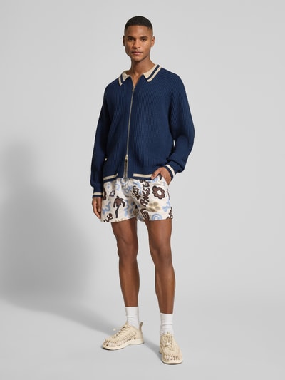 Männermodel trägt Relaxed Fit Jacke in Strick-Optik von BLKVIS in Dunkelblau mit Umlegekragen und Logo-Patch, Ganzkörperansicht von vorne.
