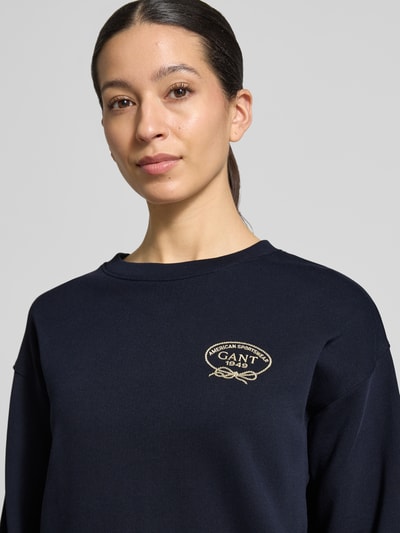 Frauenmodel trägt Sweatshirt mit Label-Stitching und Rundhalsausschnitt von Gant aus reiner Baumwolle in Dunkelblau, Nahaufnahme Oberkörper