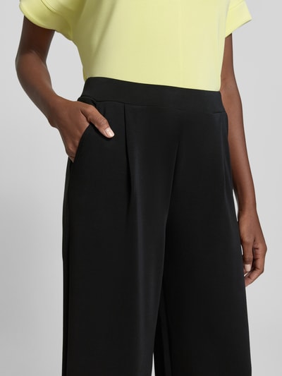 Frauenmodel trägt Regular Fit Culotte aus Modal-Mix von s.Oliver RED LABEL in Schwarz, unifarben, elastischer Bund, seitliche Eingrifftaschen, Nahaufnahme Oberkörper.