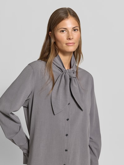 Frauenmodel trägt Regular Fit Hemdbluse mit Viskose-Anteil von MYON, Stehkragen, Knopfleiste, langarm, grauer Stoff, Nahaufnahme Oberkörper.