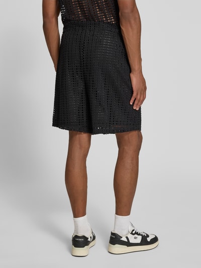 Männermodel trägt Straight Fit Shorts in Loch-Optik von COLUCCI, schwarze Farbe, elastischer Bund, Rückansicht Ganzkörperansicht.