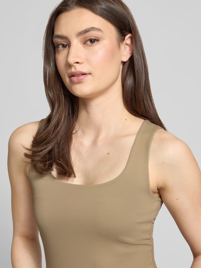 Frauenmodel trägt Slim Fit Tank Top mit U-Ausschnitt Modell 'LULA' von Pieces in Unifarbe, breite Träger, Nahaufnahme Oberkörper.