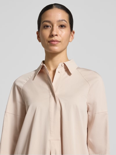 Frauenmodel trägt Hemdblusenkleid mit überschnittenen Schultern von Marc Cain in Beige aus Baumwolle mit Viskose-Anteil, 3/4-Arm, Hemdblusenkragen, verdeckte Knopfleiste, Label-Detail, Nahaufnahme Oberkörper.