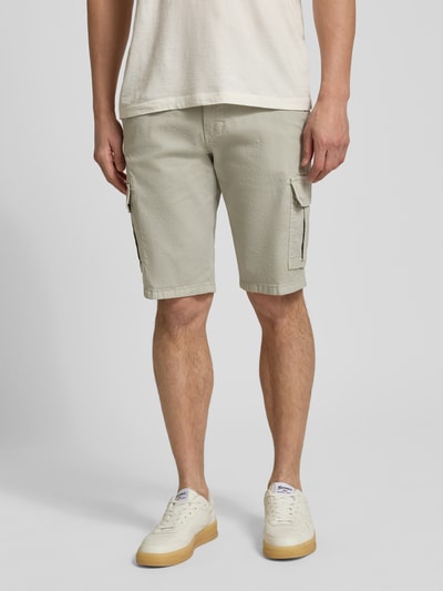 Mężczyzna nosi Bermudas mit Cargotaschen od bugatti, krój regular fit, jasny beż, boczne kieszenie cargo, szerokość w rozmiarze 50: 45 cm, długość nogawki od wewnątrz w rozmiarze 50: 30 cm, widok całej sylwetki z przodu