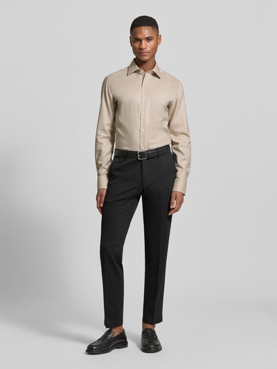 Männermodel trägt Slim Fit Businesshemd aus reiner Baumwolle Modell 'HANK' von BOSS, Optik: Unifarben/Strukturiert, Kentkragen, durchgehende Knopfleiste, Label-Applikation, Langarm, Manschette, bügelleicht, Materialverarbeitung: Piqué, Ganzkörperansicht von vorne.