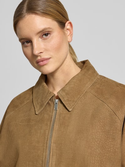 Kobiece model nosi kurtka skórzana z koziej skóry welurowej, krój relaxed fit, wpuszczane kieszenie, model 'estelle' marki Gestuz, zamek błyskawiczny, wykładany kołnierz, zbliżenie na górną część ciała