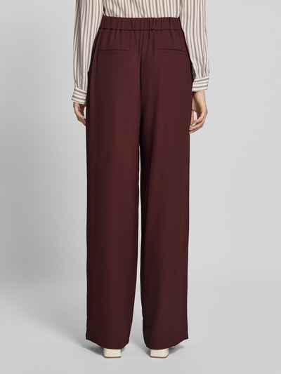 Frauenmodel trägt Wide Fit Hose mit Gesäßtaschen von Jake*s Collection in Dunkelrot, teilelastischer Bund, glatte Textur, Ganzkörperansicht Rückansicht.