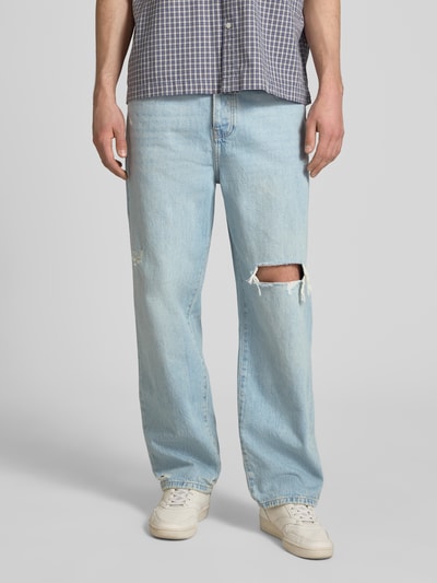 Männermodel trägt Loose Fit Jeans aus reiner Baumwolle Modell 'FADE' von Only & Sons, hellblauer Denim mit Destroyed-Details, 5-Pocket, Nahaufnahme Vorderansicht.