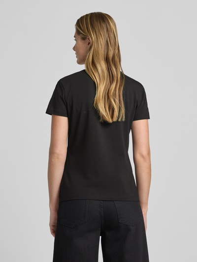 Frauenmodel trägt T-Shirt mit Logo Modell 'BRIANA' von Guess Activewear, schwarz, Baumwoll-Elasthan-Mix, Ganzkörperansicht Rückansicht.