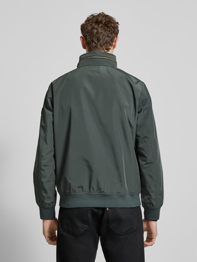 Männermodel trägt Regular Fit Jacke mit Kapuze Modell 'Como' von NAUTGÅRD, dunkelgrün, glatte Struktur, Rückenansicht, Ganzkörperansicht Rückansicht.