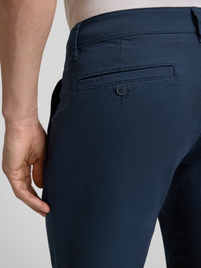 Mężczyzna nosi Regular Fit Bermudas aus Baumwoll-Mix Modell 'PHOENIX' von s.Oliver RED LABEL, kolor granatowy, twill, detal kieszeni, materiał bawełniany, krój regular fit, długość cropped, gładka faktura, widoczne szlufki, ujęcie detailaufnahme tylnej części.