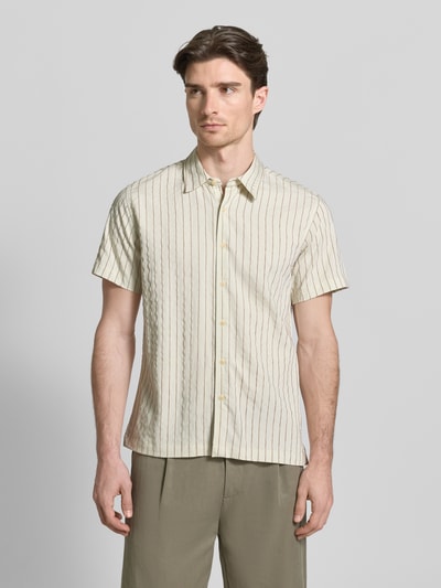 Männermodel trägt Regular Fit Freizeithemd mit Viskose-Anteil Modell 'REDFORD' von Guess, Kentkragen, creme mit Streifen, Ganzkörperansicht von vorne.