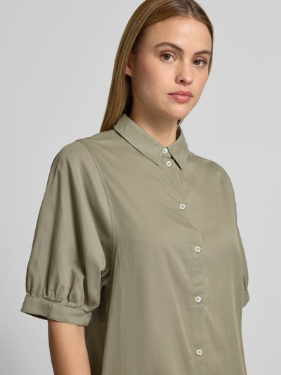 Frauenmodel trägt Relaxed Fit Hemdkleid im Halbarm-Design von Juvia in hellem Olivgrün, reine Baumwolle, Nahaufnahme Oberkörper.