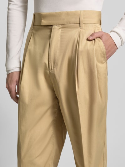 Mężczyznamodel nosi Straight Leg Chino aus reiner Baumwolle Modell 'CELEG261' od HUGO, beżowy, krój prosty, detal z zakładką, kieszenie, stitchowane logo, zapięcie na haftkę i kryty zamek, bawełna, zbliżenie na przednią część spodni.