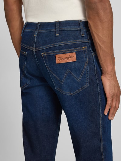 Männermodel trägt Straight Fit Jeans im 5-Pocket-Design Modell 'Texas' von Wrangler, Baumwoll-Mix mit Stretch-Anteil, Detailaufnahme Rückansicht.