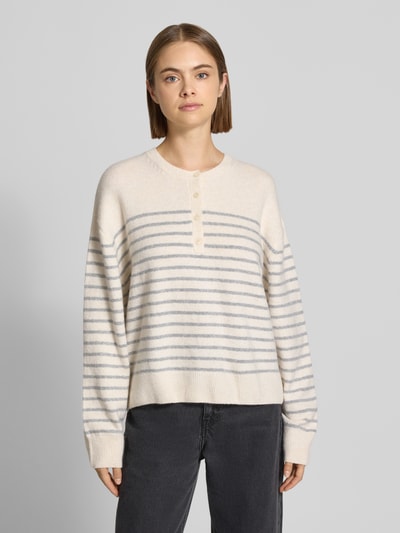 Vrouwenmodel draagt Relaxed Fit Pullover in tricotlook van REVIEW, Henley-kraag, schouderpartijen, licht met grijze strepen, voorkant volledig, ruglengte maat S 55 cm, mouwlengte maat S 57 cm.