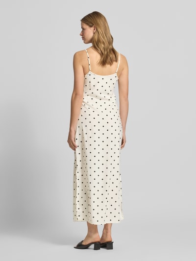 Frauenmodel trägt Maxikleid mit Spaghettiträgern Modell 'SOPHIE' von Noisy May in Creme mit schwarzen Punkten, körpernaher Schnitt, Material-Mix mit Stretch-Anteil, Ganzkörperansicht Rückansicht.