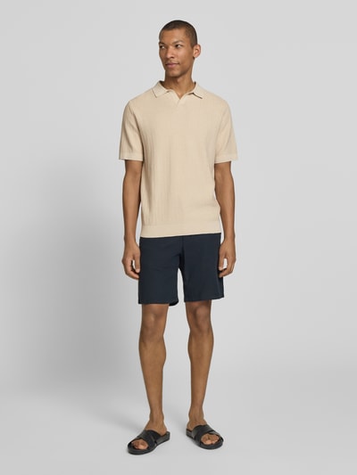 Męski model nosi Regular Fit Poloshirt aus Baumwoll-Leinen-Mix Modell 'MATTIS' od SELECTED HOMME, jednolity, strukturalny, krótki rękaw, kołnierzyk polo, V-neck, łata z logo, materiał bawełna-len, widok całego ciała z przodu.