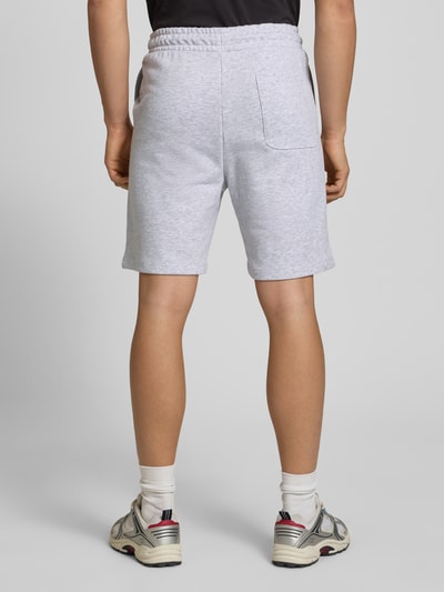 Männermodel trägt Sweatshorts mit Logo Model 'KANE' von Jack & Jones aus Baumwoll-Mix in Grau, Relaxed-Fit, Ganzkörperansicht Rückansicht.
