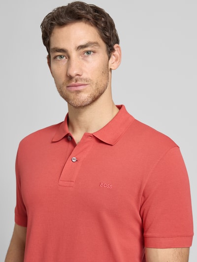Männermodel trägt Regular Fit Poloshirt aus reiner Baumwolle Modell 'PALLAS' von BOSS, Optik: Unifarben, Nahaufnahme Oberkörper.