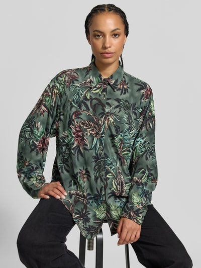 Frauenmodel trägt Hemdbluse mit floralem Allover-Print von Rabanne in Grün mit Nietenbesatz und Kentkragen, relaxed Fit, Ganzkörperansicht von vorne.
