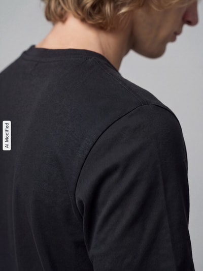 Männermodel trägt Regular Fit T-Shirt aus reiner Baumwolle von PUMA in Schwarz mit Label-Stitching, Nahaufnahme Schulter, KI-modifiziertes Bild.