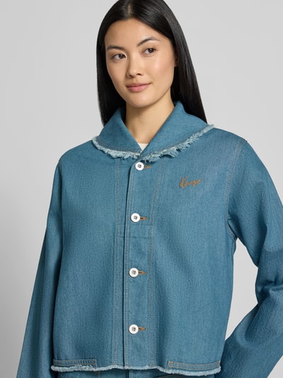 Frauenmodel trägt Regular Fit Jeansjacke mit Leinen-Anteil von KENZO in Hellblau, Knopfleiste, Label-Stitching, Nahaufnahme Oberkörper.