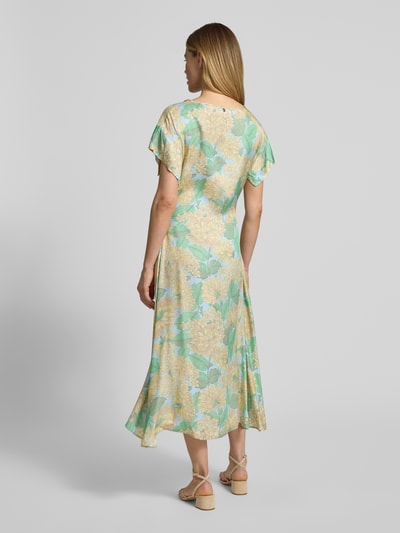 Frauenmodel trägt Midikleid aus Reine Viskose mit Bindegürtel von Rich & Royal, floraler Print in Grün und Beige, Taillierter Schnitt, U-Boot-Ausschnitt, Rückenlänge 123 cm, Brustweite 50 cm, Ärmellänge 9 cm, Ganzkörperansicht Rückansicht.