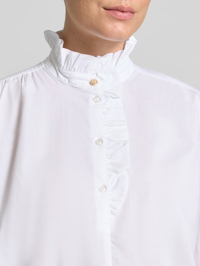 Vrouwenmodel draagt Bluse mit Rüschen und kurzer Knopfleiste van Christian Berg Woman in wit katoenmix met stretch, regular fit, opstaande kraag met ruches, korte knoopsluiting, afgeronde zoom, detailopname bovenlichaam.