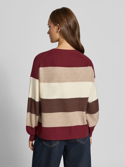 Kobieta modelka nosi Regular Fit Pullover aus Viskose-Mix model 'LATIA' od ONLY w kolorze bordowym, beżowym i kremowym, szerokie poziome pasy, tekstura dzianiny, sweter damski od ONLY, widok całej sylwetki z tyłu.