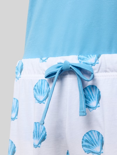 Frauenmodel trägt Regular Fit Pyjama mit Schleifen-Detail von LOUIS & LOUISA in Hellblau und Weiß, reine Baumwolle, Nahaufnahme Hüfte.