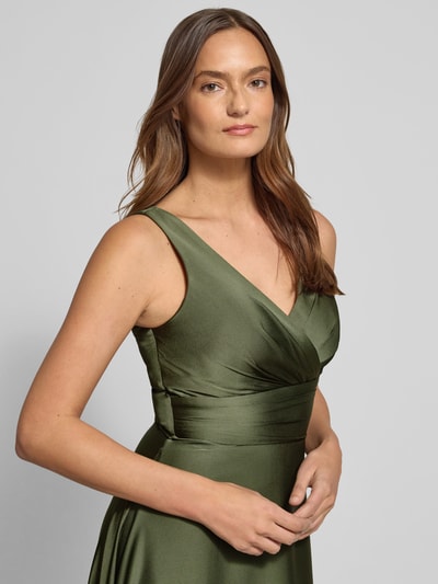 Vrouwenmodel draagt Avondjurk van satijn met V-hals van TROYDEN COLLECTION in olijfgroen, figuurvolgend, maxi-jurk, detailopname bovenlichaam. Ruglengte maat 36: 145 cm, busteomvang maat 36: 34 cm.