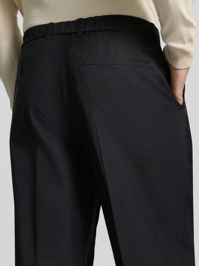 Männermodel trägt schwarze Hose aus Woll-Mix mit weitem Bein und Gesäßtasche von CK Calvin Klein, Nahaufnahme Rückansicht.