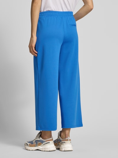 Frauenmodel trägt Wide Fit Hose mit elastischem Bund Modell 'Kate' von ICHI aus blauem Material-Mix mit Viskose-Anteil, Ganzkörperansicht Rückansicht.