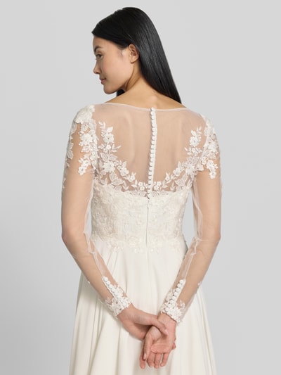 Frauenmodel trägt Brautkleid mit Stitchings und V-Ausschnitt von LUXUAR FASHION, Chiffon, A-Linie, Maxikleid in Creme mit floralen Spitzendetails, Transparenzen und Knopfleiste, Rückenlänge 132 cm, Ganzkörperansicht Rückansicht.