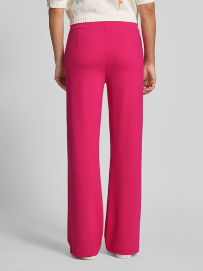 Frauenmodel trägt Flared Cut Hose mit elastischem Bund von Smith and Soul aus pinkem Material-Mix mit Viskose-Anteil, Ganzkörperansicht Rückansicht.