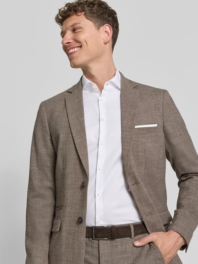Männermodel trägt Slim Fit Anzugsakko mit Woll-Anteil Modell 'SLIM-OASIS' von SELECTED HOMME in melange braun, Twill, Nahaufnahme Oberkörper.
