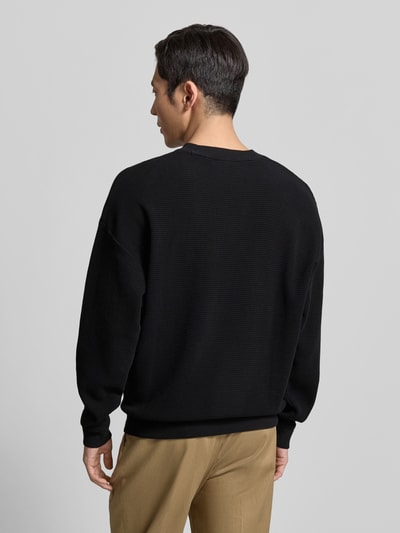 Männermodel trägt Regular Fit Sweatshirt aus reiner Baumwolle Modell 'DAFFLYN' von HUGO in Schwarz mit Strukturmuster, Ganzkörperansicht Rückansicht.