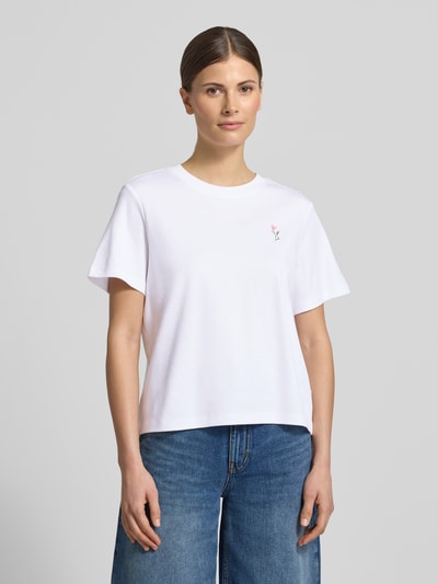Modelka kobieca nosi Regular Fit T-Shirt aus reiner Baumwolle od s.Oliver RED LABEL w białym kolorze, z motywem na piersi, krótki rękaw, materiał jersey, krój regular fit, widok całej sylwetki z przodu.