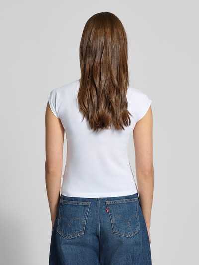 Frauenmodel trägt Slim Fit T-Shirt mit Logo-Stitching von Guess Jeans, weißer Baumwoll-Mix, Rundhalsausschnitt, Rückenlänge 48 cm, Ganzkörperansicht Rückansicht.