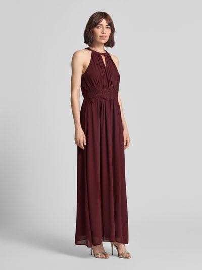 Frauenmodel trägt Abendkleid mit Taillenband Modell 'MILINA' von VILA, bordeaux, Chiffon, taillierter Schnitt, Maxikleid, Ganzkörperansicht von vorne.