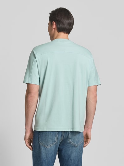 Männermodel trägt Regular Fit T-Shirt aus reiner Baumwolle Modell 'TE_BAYMESH' von BOSS Orange in Hellblau, unifarben, Ganzkörperansicht Rückansicht.