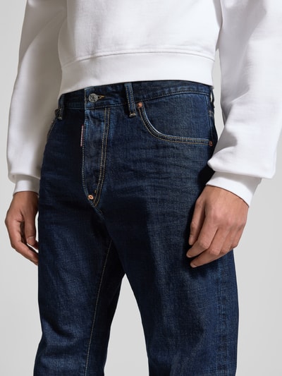 Männermodel trägt Straight Fit Jeans aus reiner Baumwolle von Dsquared2 in Dunkelblau mit 5-Pocket-Design und Label-Detail, Nahaufnahme Oberkörper.