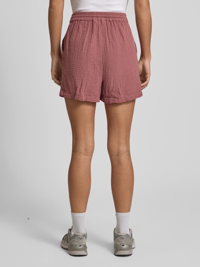 Männermodel trägt Relaxed Fit Shorts aus reiner Baumwolle Modell 'THYRA' von Only in Uni-Optik, elastischer Bund, seitliche Taschen, crêpe-Struktur, Ganzkörperansicht Rückansicht