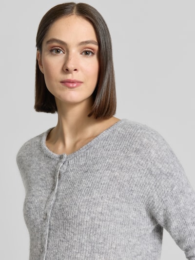 Frauenmodel trägt Regular Fit Strickjacke aus Woll-Alpaka-Mix Modell 'Almine' von MOS MOSH, meliertes Hellgrau, Nahaufnahme Oberkörper.