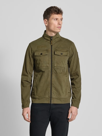 Mannelijk model draagt Jacke mit Stehkragen und Brusttaschen van PME Legend in olijfgroen, puur katoen, regular fit, opstaande kraag, ritssluiting, borstzakken, ruglengte maat M 67 cm, schouderbreedte 46 cm, borstwijdte 58 cm, mouwlengte 65 cm. Ganzkörperansicht van voren.