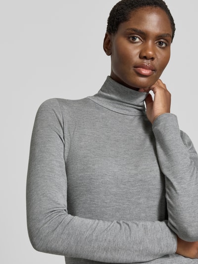 Frauenmodel trägt Longsleeve mit Rollkragen von someday in Grauton, eng anliegend, Ripp-Struktur, Viskose-Mix mit Stretch, Nahaufnahme Oberkörper.