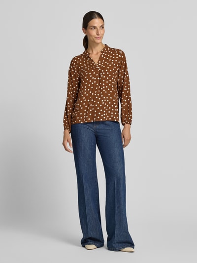Frauenmodel trägt Relaxed Fit Bluse aus reiner Viskose-Mix Modell 'Valeria' von ZABAIONE, braun mit weißen Punkten, Ganzkörperansicht von vorne, Damen Bluse, Serafino Ausschnitt, langärmelig, Rückenlänge 54 cm, Ärmellänge 58 cm.